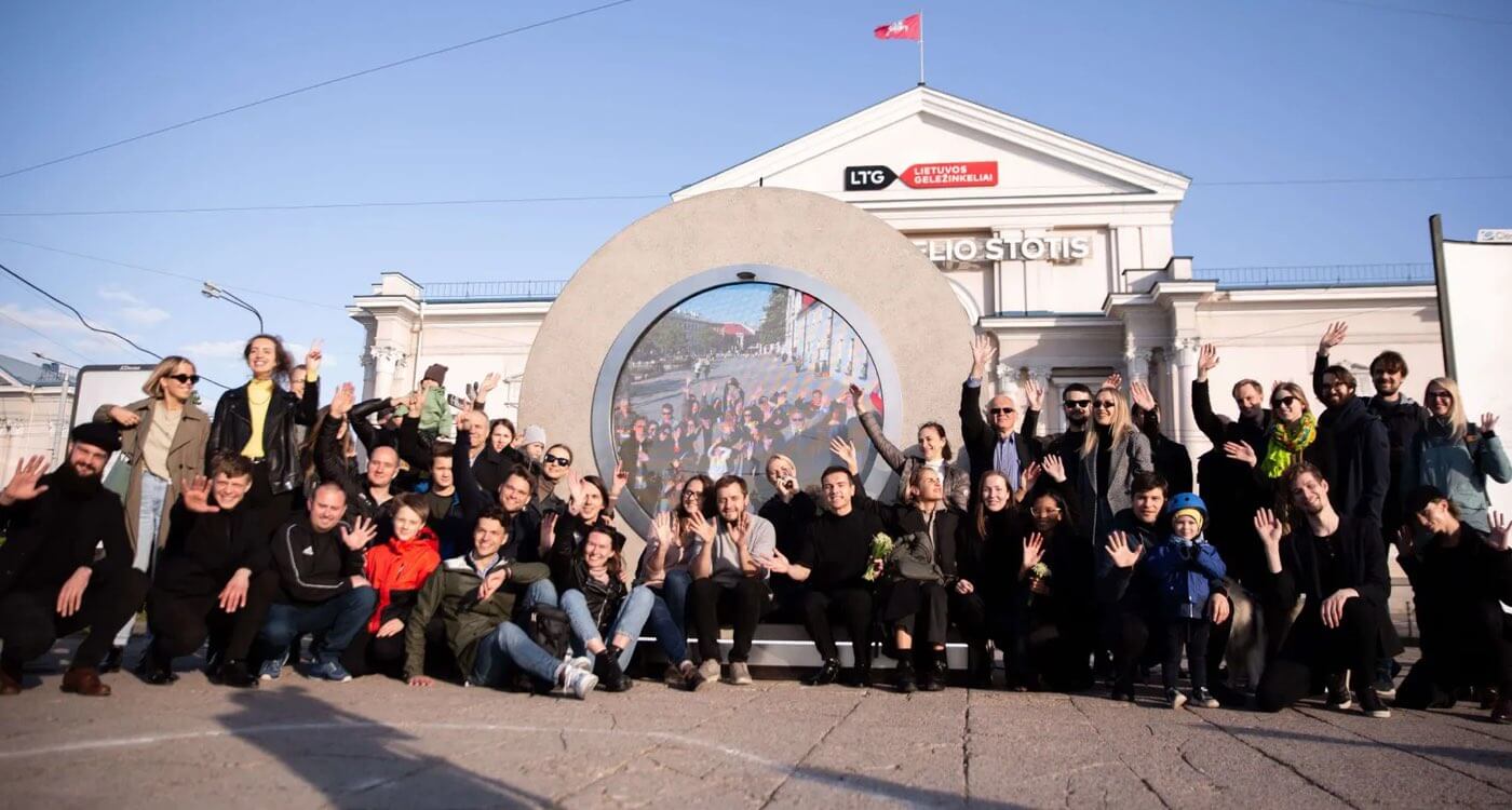 Grupa ludzi przed portalem w Wilnie