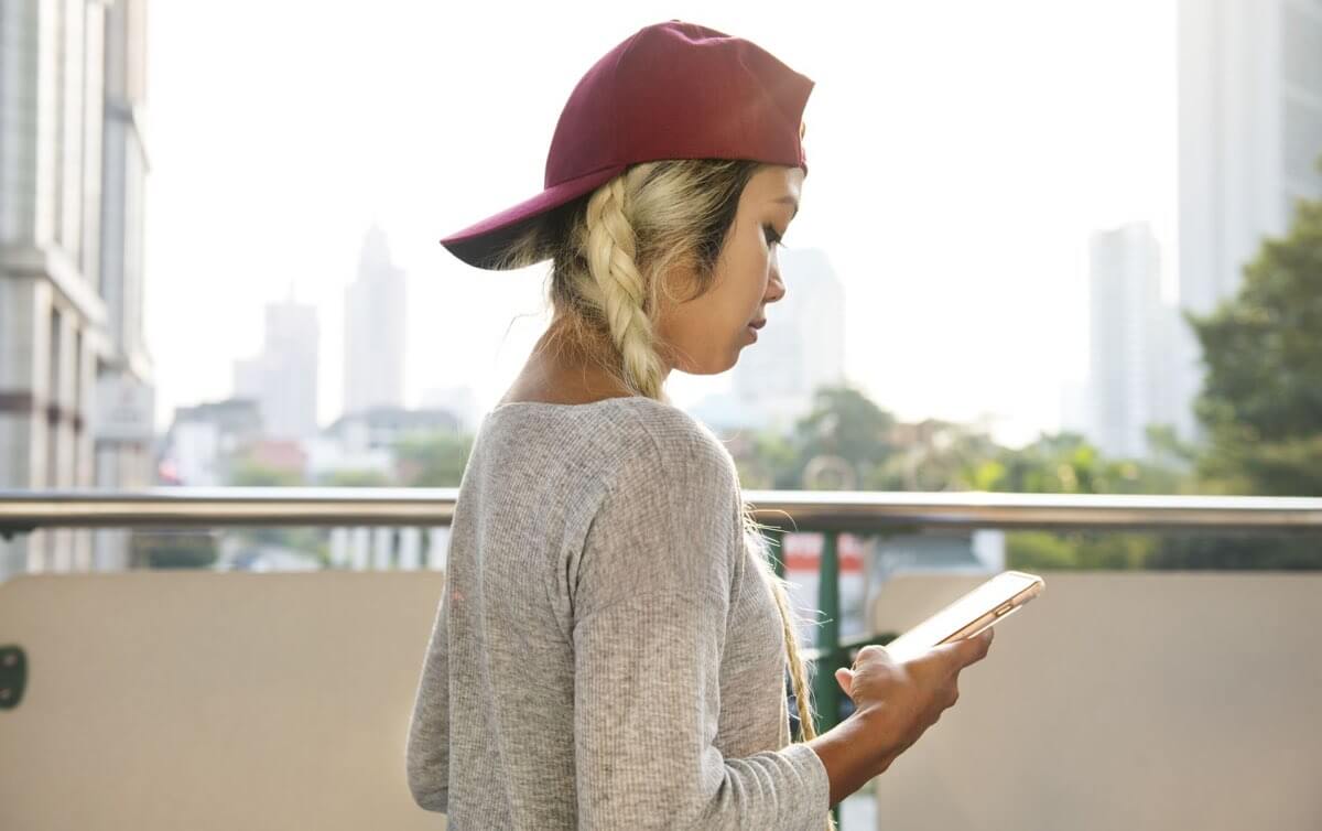 Kobieta w czerwonej czapce ze smartfonem w ręku